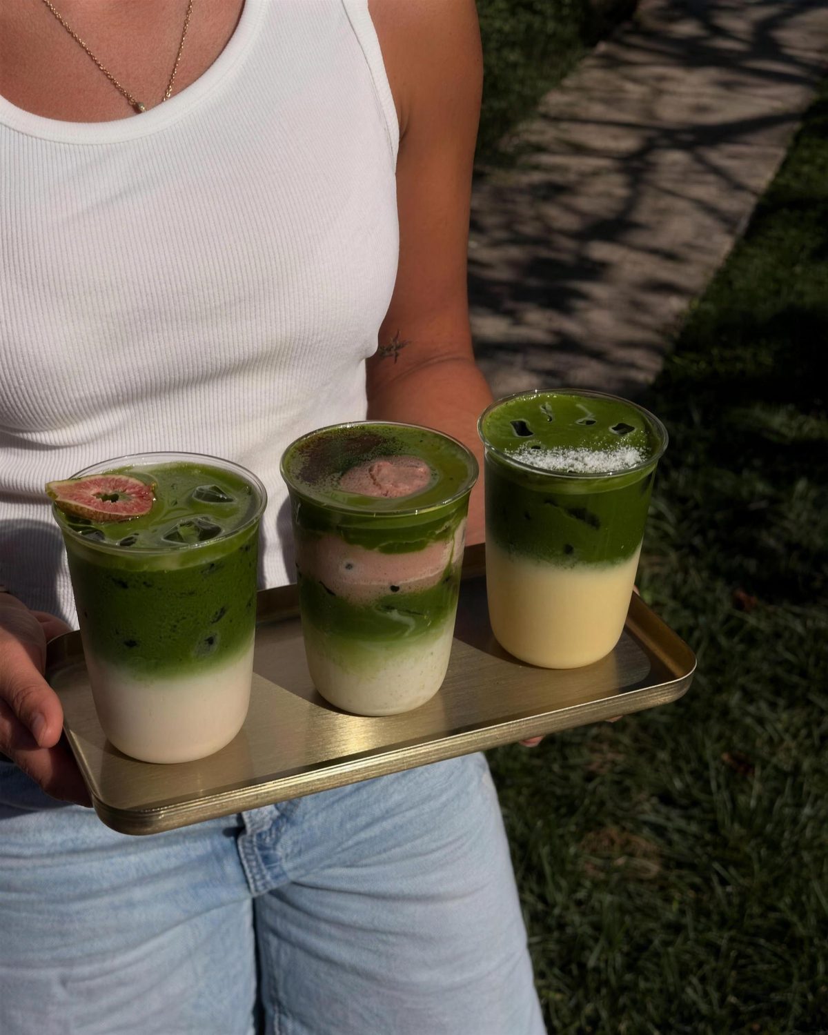 A tray of three layered matcha drinks
